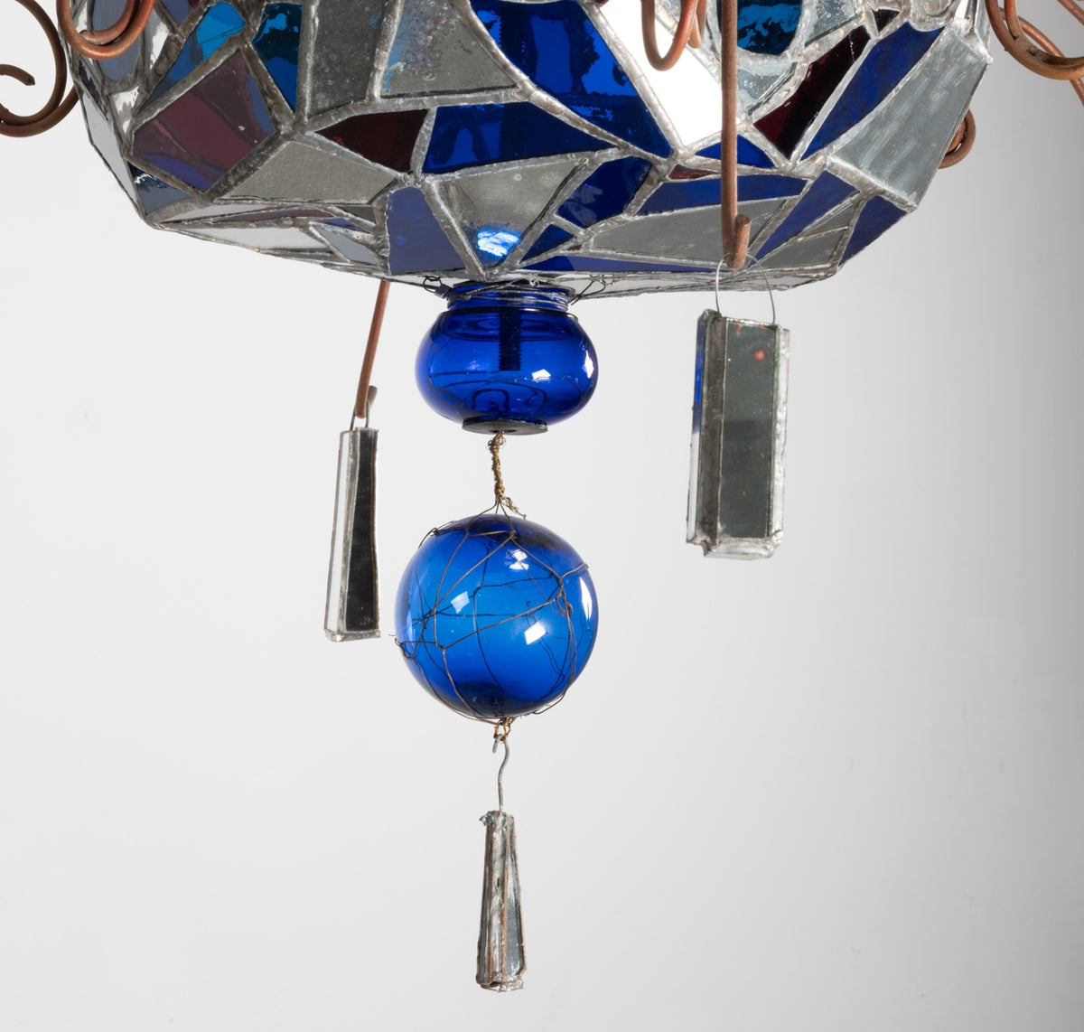 Détail du dessous du lustre de Dubreuil et Dixon : verre et miroirs assemblés au plomb, boules de verre bleu et pendentifs en miroir