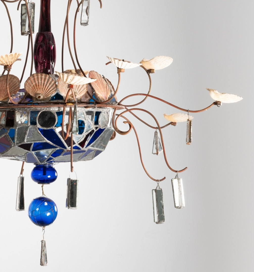 Détail du lustre de Dubreuil et Dixon : bras en fer forgé à coquillages, coupe en verre et miroirs assemblés au plomb, boules bleues et pendentifs en miroir