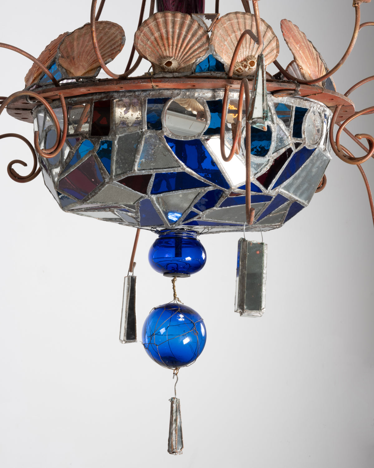 Détail du lustre de Dubreuil et Dixon : coupe en verre bleu, rouge et miroirs assemblés au plomb, boules bleues et pampille