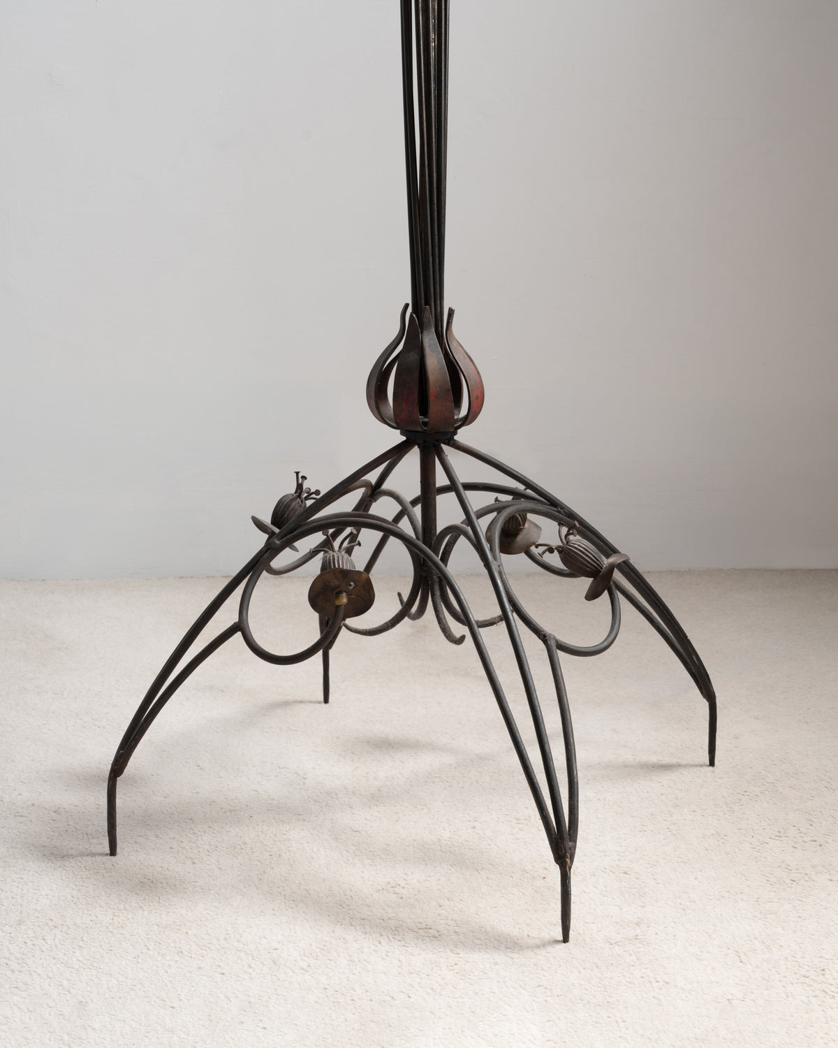 Détail du pied du lampadaire « Pavot » de Dubreuil : quatre pieds arqués, enroulements et petites capsules en fer forgé