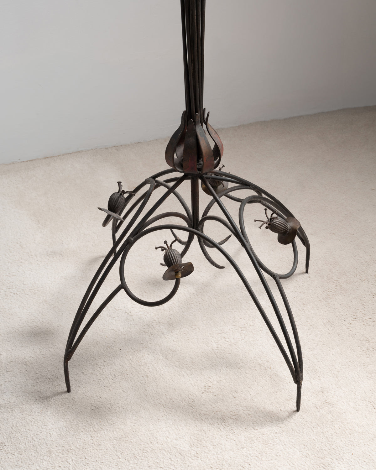 Détail du pied du lampadaire « Pavot » de Dubreuil : base en fer forgé aux enroulements ornés de capsules de pavot