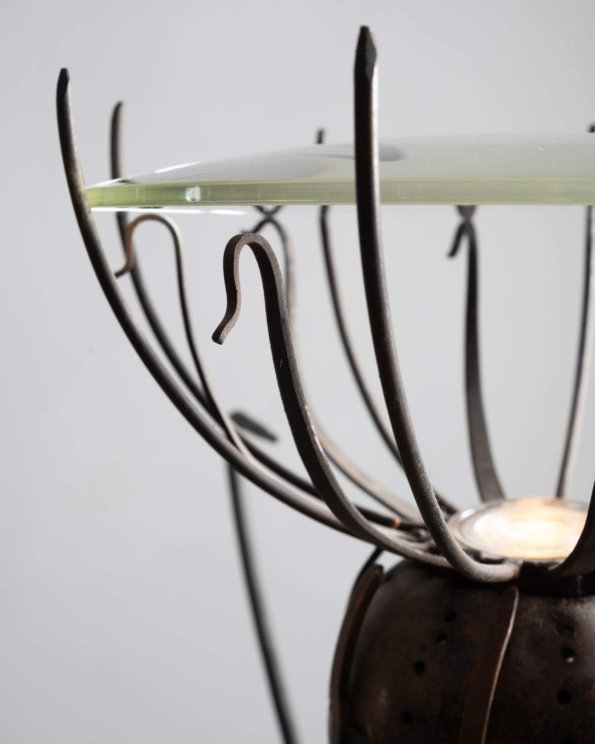 Gros plan sur le bord de la coupe en verre et les tiges recourbées du lampadaire « Pavot » de Dubreuil