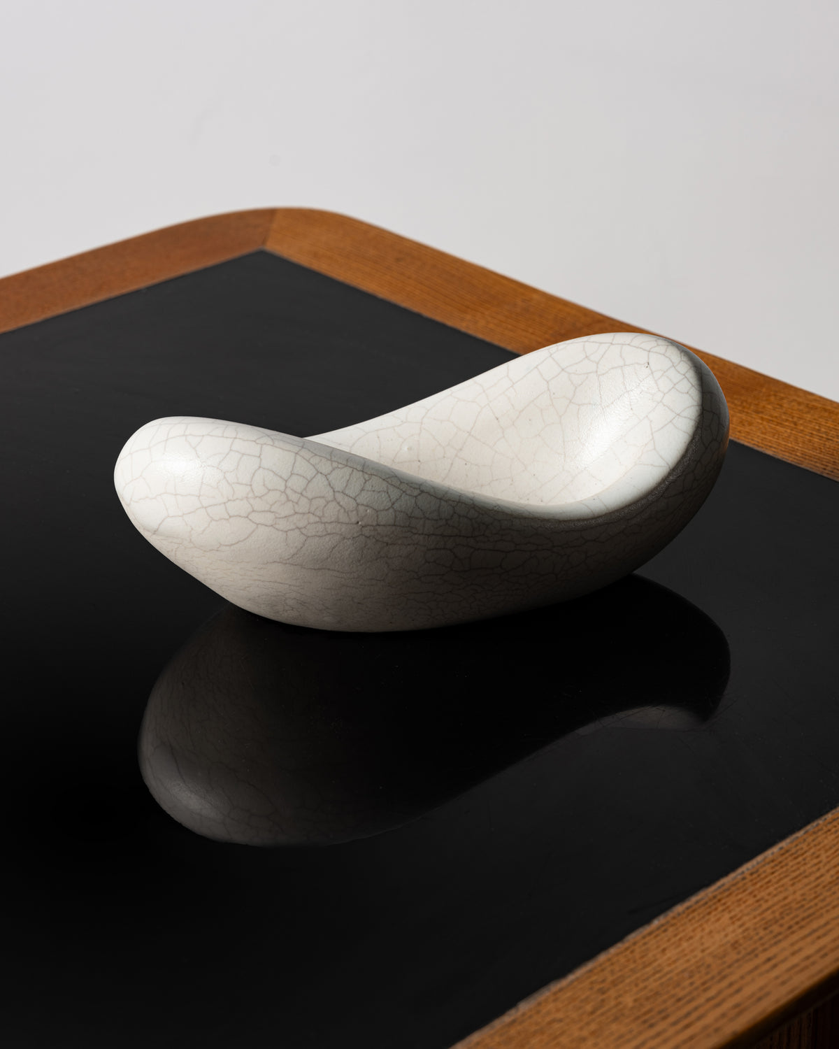 Coupe « Banane » de Georges Jouve vue de trois-quarts, forme libre en céramique blanche craquelée