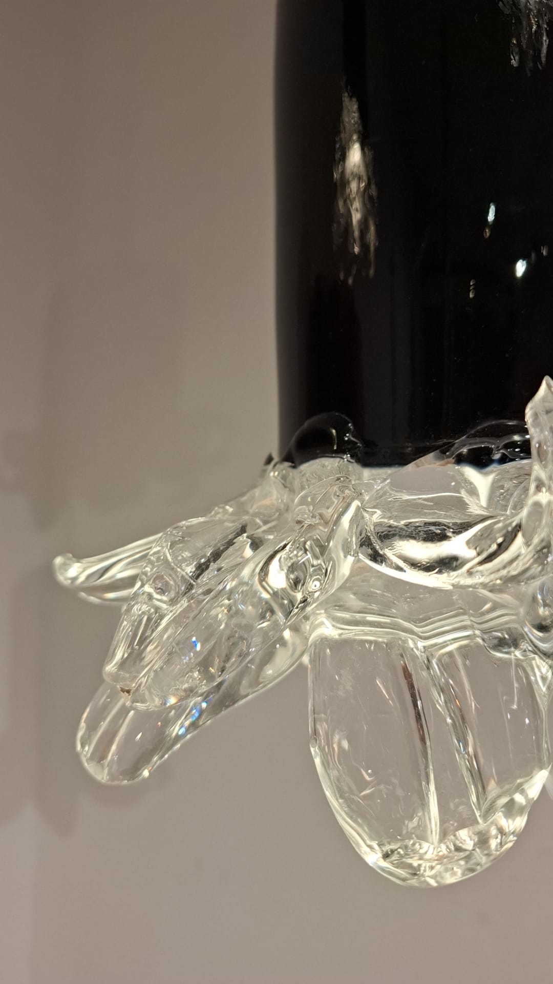 Détail d'une suspension en verre de Murano noir terminée par des feuilles de cristal transparent, circa 1960
